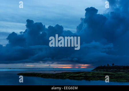 I pescatori pausa per guardare il tramonto a Sunabe Beach a Okinawa, Giappone. Foto Stock