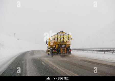 Un aratro di neve funziona per mantenere l'autostrada M74 in Scozia è aperta come la neve continua a cadere in tutta la mattina presto portare pericolose condizioni di guida per gran parte della Scozia. Foto Stock