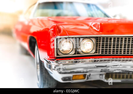 Close up dettaglio di rosso lucido auto classica con focus sui fari e cofano. Foto Stock