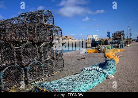 Aragosta e granchio pentole, e una rete da pesca al porto, a Dunbar, East Lothian, Scozia. Foto Stock