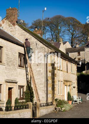 Regno Unito, Derbyshire, Tideswell, High Street, il vecchio mercato del bestiame copritetti sostituzione ardesie del cottage Foto Stock