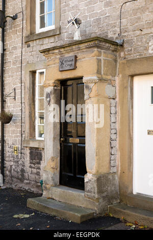 Regno Unito, Derbyshire, Tideswell, High Street, portico di pietra di Mulino a Vento Cottage Foto Stock