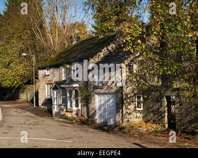 Regno Unito, Derbyshire, Tideswell, High Street, Vicarage Cottage in pezzata luce autunnale Foto Stock