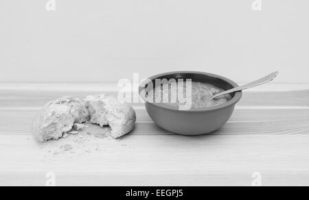 Ciotola di una deliziosa minestra di verdura con pane strappato a metà - elaborazione monocromatica Foto Stock