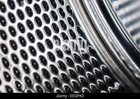 Macro shot dell'interno di un cesto della macchina di lavaggio che mostra i fori di scarico Foto Stock