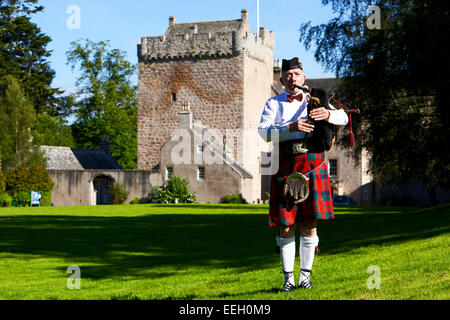 Cornamuse scozzesi giocatore giocare tubi nella parte anteriore del castello di Scozia Foto Stock