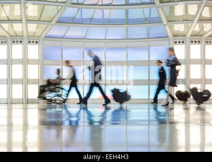 Regno terminale tunnel pedonale all'Aeroporto Internazionale Chicago O'Hare. Persone disabili su sedia a rotelle cabina equipaggio di volo a piedi Foto Stock