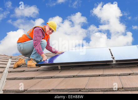 Lavoratore esperto controllo di pannelli solari sul tetto della casa Foto Stock