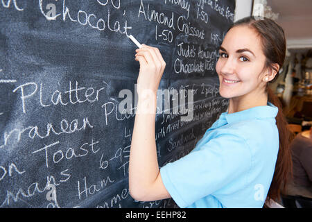 Cameriera In Ristorante Menu scrittura sulla lavagna Foto Stock