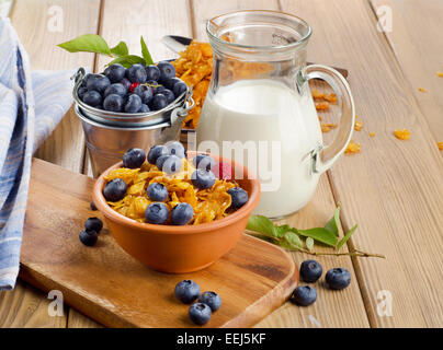 Una sana prima colazione - corn flakes con mirtilli freschi e latte. Messa a fuoco selettiva Foto Stock