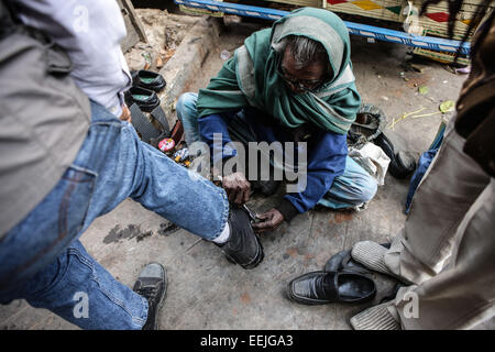 (150119) -- CALCUTTA, Gennaio 19, 2015 (Xinhua) -- Un shoeblack pulisce una calzatura per un cliente in Calcutta, capitale dell'est lo stato indiano del Bengala Occidentale, Gennaio 19, 2015. Come una crescente metropolitan city in un paese in via di sviluppo, Calcutta affronta un sostanziale inquinamento urbano, congestione del traffico, la povertà, la sovrappopolazione, e altri problemi socioeconomici. (Xinhua/Zheng Huansong) Foto Stock