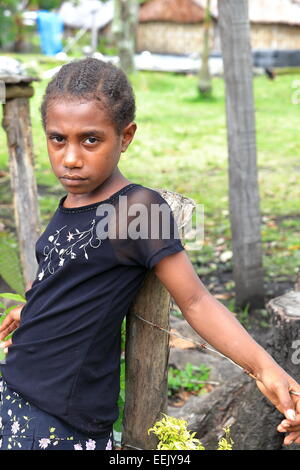 AMBRYM,VANUATU-ottobre 6, 2014: ragazza triste acquista frutto in un negozio locale sulla strada del ritorno a casa dopo la scuola il 6 ottobre in Melvert-Vanua Foto Stock