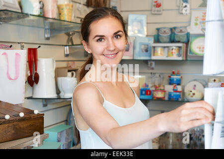 Giovane donna nel negozio di articoli da regalo scegliendo la scheda Messaggi di saluto Foto Stock