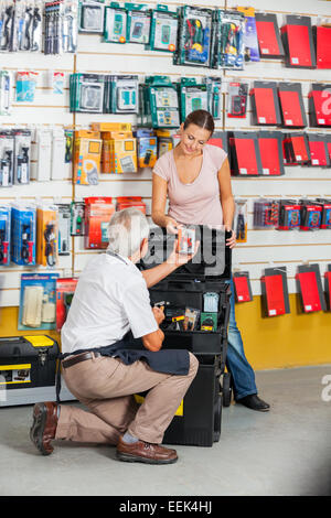 Venditore ad assistere il cliente nel negozio di ferramenta Foto Stock