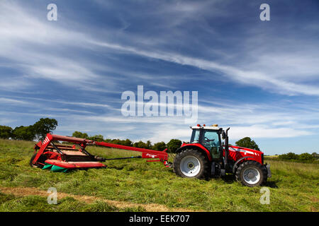 Agricoltore la falciatura di erba per haylage in estate in Norfolk, Regno Unito Foto Stock