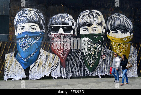 Beatles, indossa una bandana colorata fazzoletti da naso e da taschino,dipinto sul muro, graffiti l uomo e la donna a piedi passato in primo piano Foto Stock