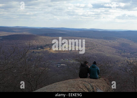 Due escursionisti prendere un periodo di riposo e osservare il panorama in Hudson Highlands stato parco in autunno Foto Stock