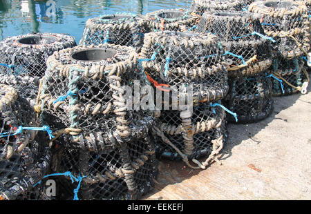 Una pila di pentole di pesca su una parete del porto. Foto Stock