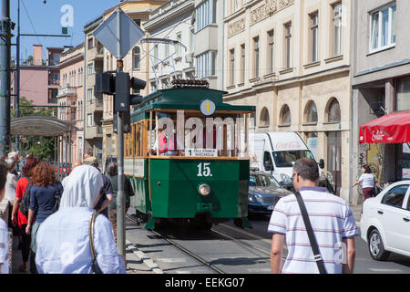 Un vecchio-stile tram lungo Obala dei Kulina Bana street e il fiume Miljacka. Sarajevo, Bosnia Erzegovina Foto Stock