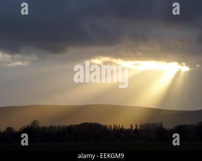 Un raggio di sole fa capolino tra le nuvole scure Foto Stock