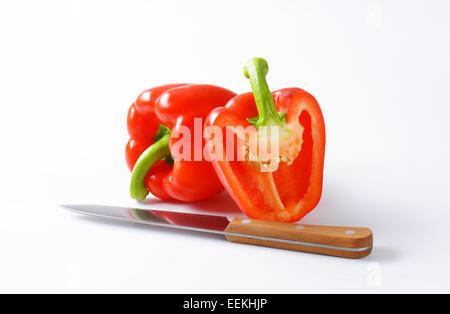 L'uno e metà peperone rosso con coltello da cucina Foto Stock