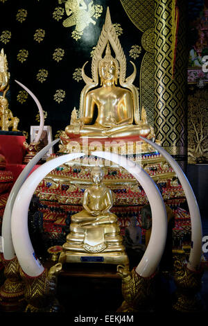 Un Buddha figura all'interno della pagoda di Wat Neramit Wipattasana tempio che è famosa per le sue grandi dimensioni ordinazione hall e la pagoda costruita di colore rosso laterite nella provincia settentrionale di Loei in Thailandia Foto Stock