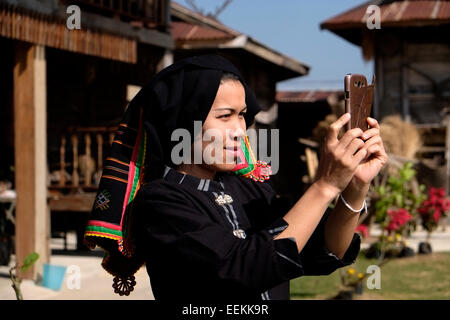 Una donna di Tai Dum minoranza etnica noto come 'il popolo senza un paese" i cui antenati avevano migrato dal Laos nel 1905 indossa tipico abito nero e prendendo un selfie in Tai Dam villaggio di Ban Napanard situato a divieto Na Pa Nat, Tambon Khao Kaeo nella parte settentrionale della provincia di Loei Thailandia Foto Stock