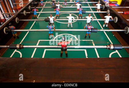 Calcio da tavolo nel bar, visibile nelle figure del giocattolo mini football giocatori indossando il Real Madrid e Barcellona Calcio team Foto Stock