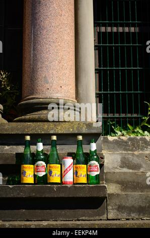 Bere bottiglie e lattine a sinistra su un monumento nella necropoli di Glasgow Foto Stock