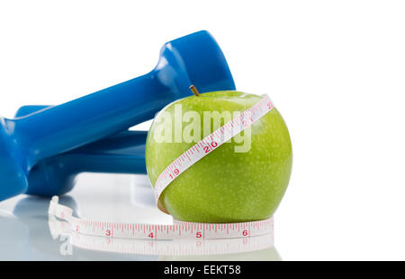 Verde incontaminato apple, due manubri, nastro di misurazione isolata su bianco con la riflessione. Abbondanza di spazio copia. Foto Stock