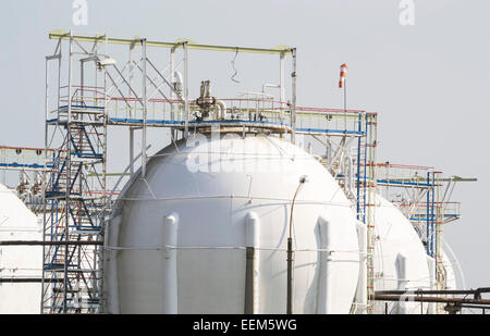 Serbatoi sferici contenenti gas naturale liquefatto su una piattaforma di raffineria Foto Stock