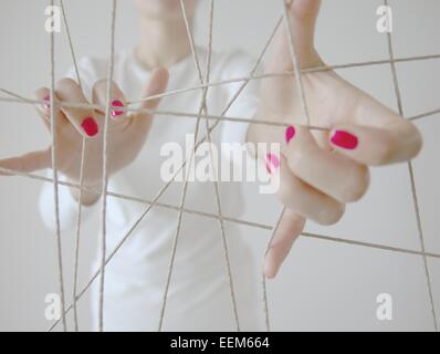 Donna con le mani in mano e del gatto di corda culla Foto Stock