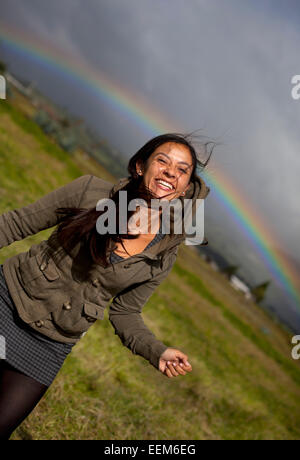 Ecuador, Cayambe, Donna sorridente con rainbow in background, Cayambe, Ecuador Foto Stock