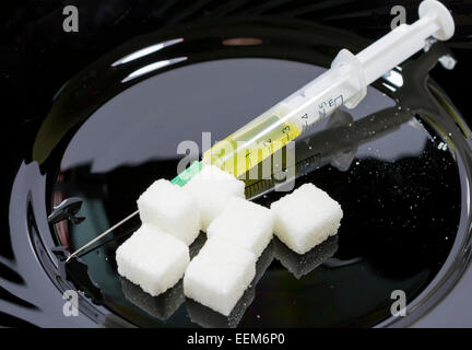 Più zucchero bianco i cubi su piastra nera con coltello e forchetta in disparte , concetto per il diabete e la nutrizione Foto Stock