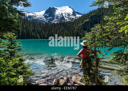 Femmina Hiker che guarda il lago Middle Joffre, Joffre Lakes Provincial Park, British Columbia, Canada Foto Stock