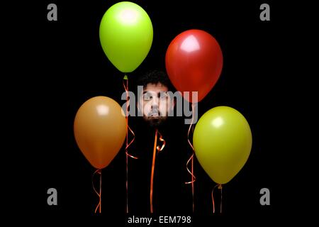 Uomo di testa su nastro con palloncini multicolori Foto Stock