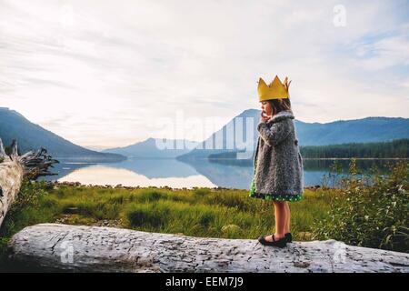 Ragazza in piedi su un log che indossa una corona Foto Stock