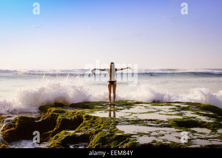 Indonesia, Bali, donna in piedi di fronte al mare Foto Stock