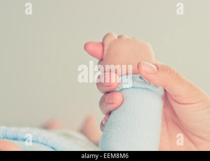 Primo piano di una mano di una madre che tiene la mano del bambino ragazzo Foto Stock