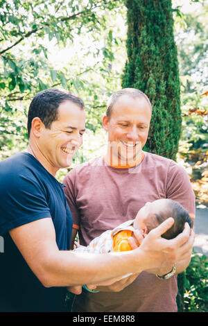 Gay caucasico giovane azienda baby boy all'aperto Foto Stock