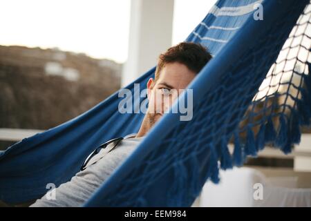 Uomo sorridente sdraiato in un'amaca Foto Stock