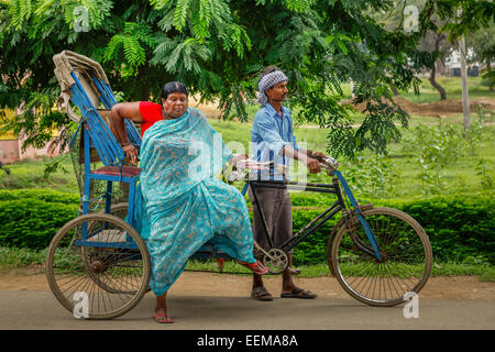 Donna sari-placcata scendere da un risciò ciclo sul viale principale a Bodh Gaya, Bihar, India. Foto Stock