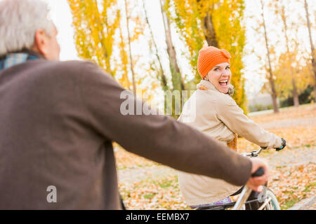 I vecchi Caucasian giovane equitazione biciclette su foglie di autunno Foto Stock