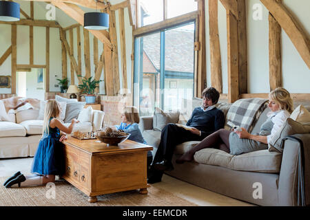 Famiglia caucasica rilassante nella stanza vivente Foto Stock