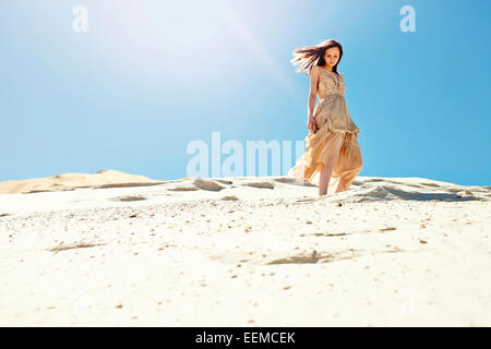 La donna caucasica camminando sulla duna di sabbia hill Foto Stock