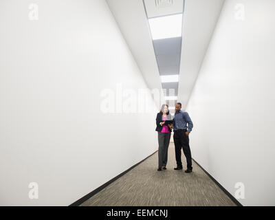 La gente di affari di parlare nel corridoio di office Foto Stock