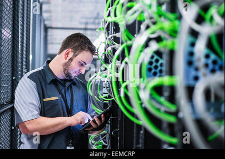 Caucasian tecnico utilizzando tavoletta digitale in sala server Foto Stock