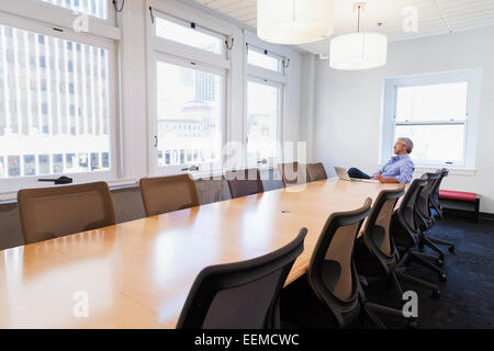 Imprenditore seduto al tavolo della sala conferenze Foto Stock
