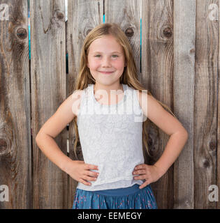 Caucasian ragazza sorridente con le mani sui fianchi Foto Stock