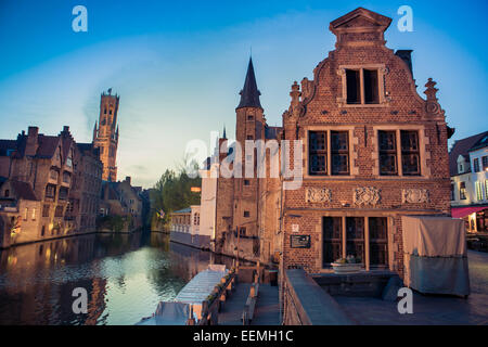 Belfort-Hallen torre campanaria dal canale in corrispondenza di Rozenhoedkaai accesa fino al crepuscolo, Bruges, Belgio Foto Stock